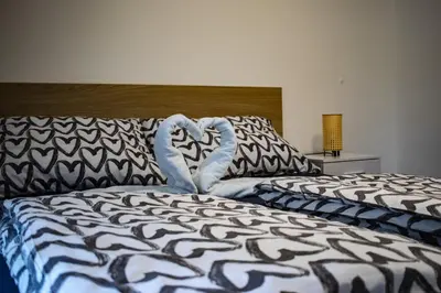 a bed with two heart shaped towels on it at Central Prague Vítkov - free parking in Prague