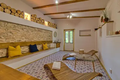a living room with a stone wall and a table and chairs at Domeček u Josefa in Mělník