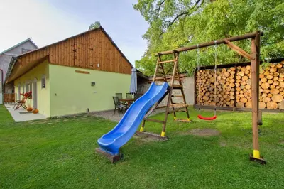 a playground with a blue slide in a yard at Domeček u Josefa in Mělník