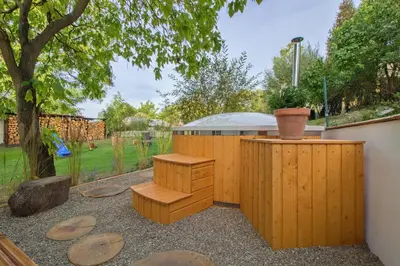 a garden with wooden benches and a tree at Domeček u Josefa in Mělník