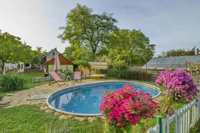 a small swimming pool in a yard with pink flowers at Domeček u Josefa in Mělník