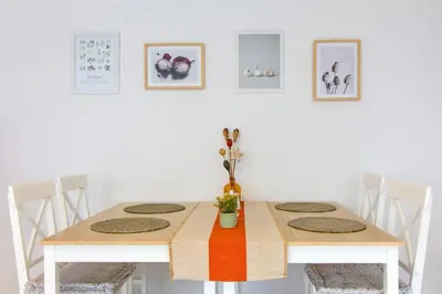 a white dining room with a wooden table and chairs at Domeček u Josefa in Mělník