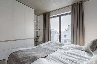 a bedroom with a bed and a large window at Aparthotel Na Klenici in Mladá Boleslav