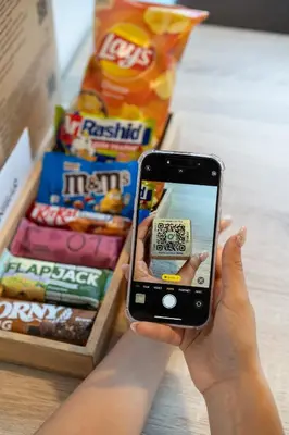 a person holding a cell phone in front of some food at Aparthotel Na Klenici in Mladá Boleslav