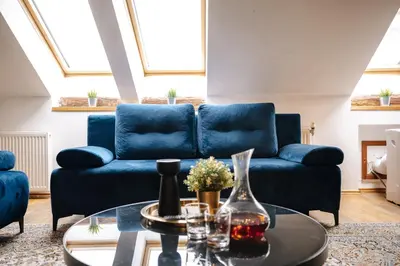 a bedroom with a bed and a chair and a couch at Stylish Central Duplex by Wagnerstays in Prague