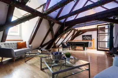 a living room with a table and a piano at Fairytale Duplex - Billiard - Whirlpool - Home Cinema - Old Town in Prague