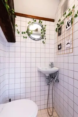 a white tiled bathroom with a sink and a mirror at Fairytale Duplex - Billiard - Whirlpool - Home Cinema - Old Town in Prague
