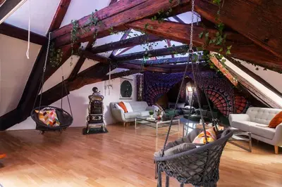 a living room filled with furniture and a wooden ceiling at Fairytale Duplex - Billiard - Whirlpool - Home Cinema - Old Town in Prague