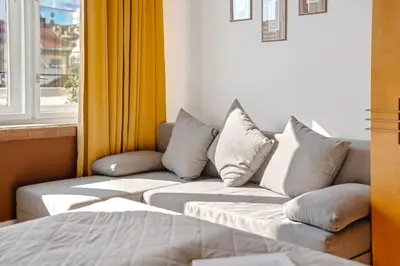 a couch with pillows in a room with a window at Waterfront River Side Roof Top Apartment - Terrace with city view in Prague
