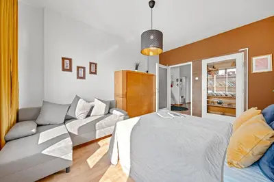 a bedroom with a bed and a couch at Waterfront River Side Roof Top Apartment - Terrace with city view in Prague