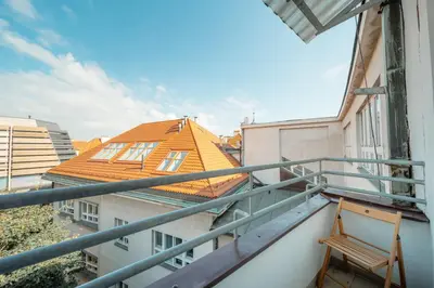 a chair on a balcony with a building at Waterfront River Side Roof Top Apartment - Terrace with city view in Prague