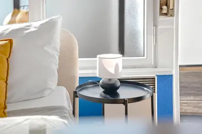 a table with a lamp on it next to a chair at Waterfront River Side Roof Top Apartment - Terrace with city view in Prague