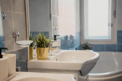 a bathroom with a sink and a mirror and a tub at Waterfront River Side Roof Top Apartment - Terrace with city view in Prague