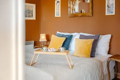 a bed with yellow and blue pillows and a table at Waterfront River Side Roof Top Apartment - Terrace with city view in Prague