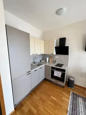 a kitchen with white cabinets and a stove top oven at Cozy apartment in Prague