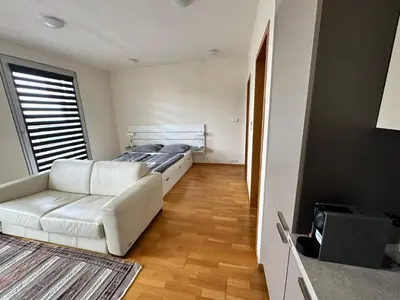 a living room with a white couch and a bed at Cozy apartment in Prague