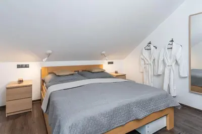 a bedroom with a bed and some clothes on hangers at ESCAPE THE ORDINARY (Sauna & Jacuzzi) in Jesenice