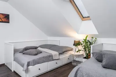 a white bedroom with two beds and a lamp at ESCAPE THE ORDINARY (Sauna & Jacuzzi) in Jesenice