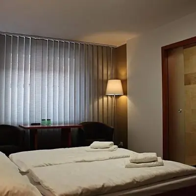 a bedroom with two beds and a lamp and a window at Ubytování u Smrku in Jeneč