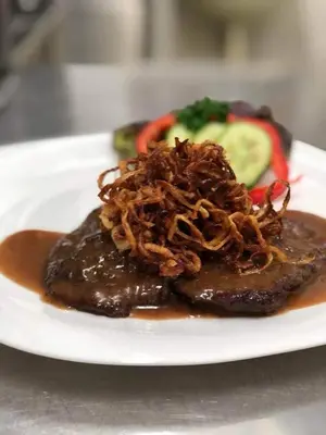 a plate of food with meat and vegetables on a table at Ubytování u Smrku in Jeneč