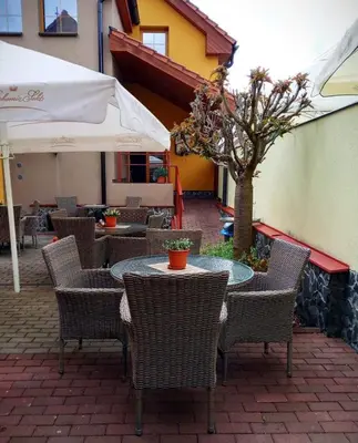 an outdoor patio with tables and chairs and a tree at Ubytování u Smrku in Jeneč
