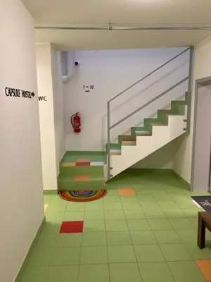 a room with a staircase and a green floor at Capsule hostel Andel Centre SPIRIT in Prague