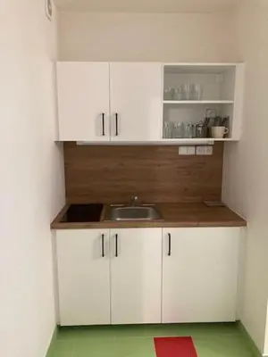 a small kitchen with white cabinets and a sink at Capsule hostel Andel Centre SPIRIT in Prague