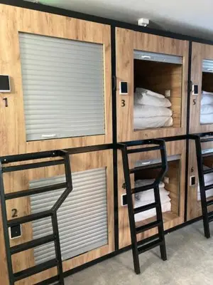 a room with two chairs and a wall with windows at Capsule hostel Andel Centre SPIRIT in Prague