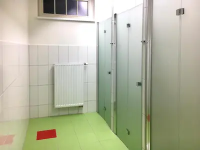 a bathroom with green stalls and a window at Capsule hostel Andel Centre SPIRIT in Prague