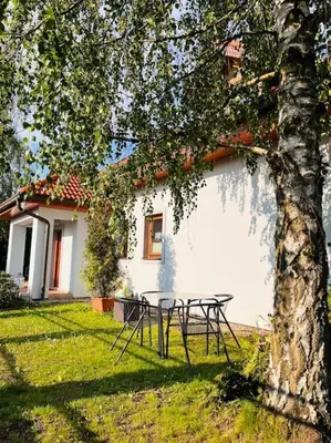 a picnic table under a tree next to a building at Apartmán se zahradou 20 minut do centra Prahy in Ořech