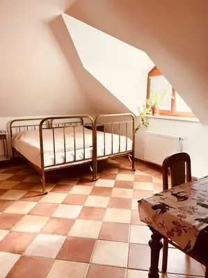 a bedroom with two beds and a table in a attic at Apartmán se zahradou 20 minut do centra Prahy in Ořech
