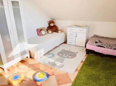 a small bedroom with a bed and a teddy bear at Apartmán se zahradou 20 minut do centra Prahy in Ořech