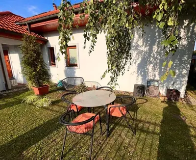 a table and chairs in the yard of a house at Apartmán se zahradou 20 minut do centra Prahy in Ořech