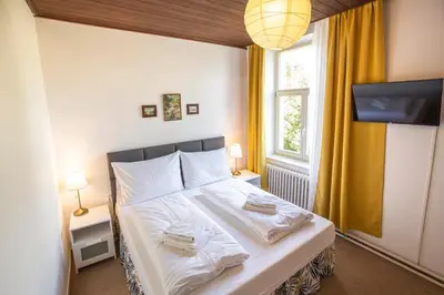 a bedroom with a bed with white sheets and a window at Pension v parku Český Šternberk in Český Šternberk