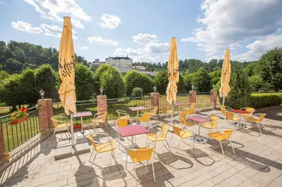a patio with tables and chairs and umbrellas at Pension v parku Český Šternberk in Český Šternberk