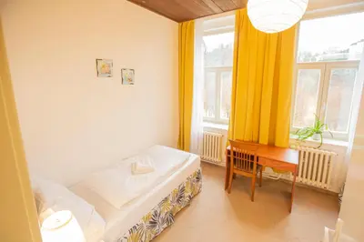 a room with a bed and a table and a window at Pension v parku Český Šternberk in Český Šternberk