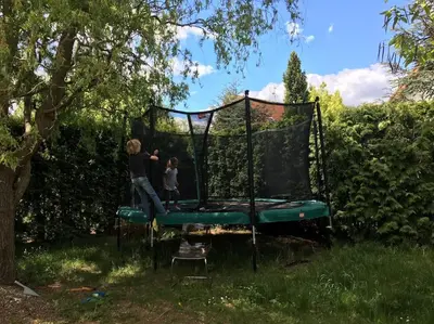 two people standing on a trampoline in a yard at Spacious villa with an outdoor pool in Černošice in Černošice