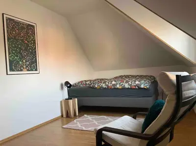 a room with a bed and a chair in a attic at Spacious villa with an outdoor pool in Černošice in Černošice