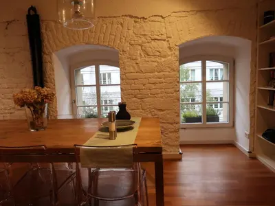 a dining room with a wooden table and two windows at Michal apartment 125m2 city centre in Prague
