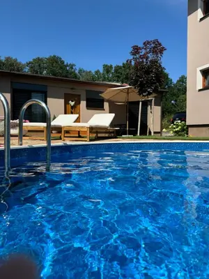 a swimming pool with blue water in front of a building at Apartmán Květinová zahrada in Prague