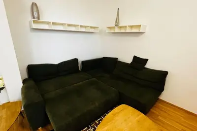 a black couch sitting in a living room at Apartment Holesovice, garden, garage in Prague