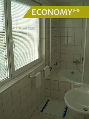 a bathroom with a bath tub and a sink at Hotel Ludmila in Mělník