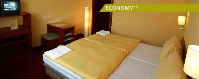 a hotel room with a bed and a television at Hotel Ludmila in Mělník
