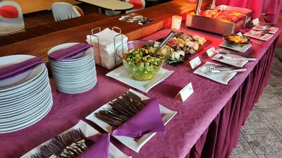 a table with plates of food on a purple table cloth at Hotel Ludmila in Mělník