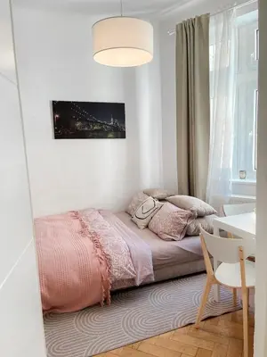 a bed in a room with a table and a window at Skolska Junior apartment in Prague