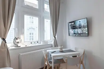 a dining room with a table and chairs and a window at Skolska Junior apartment in Prague