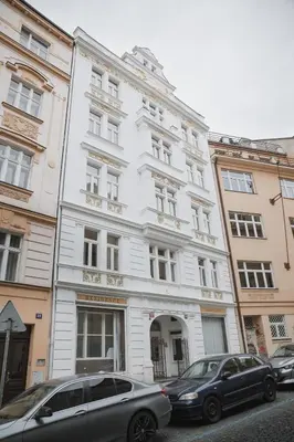 two cars parked in front of a white building at Skolska Junior apartment in Prague