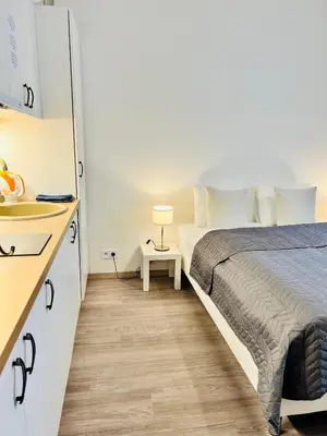 a bedroom with a bed and a table and a sink at Maria Apartment Liben in Prague