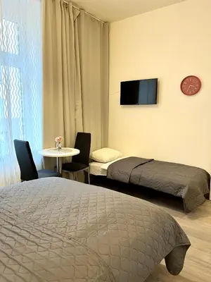 a bedroom with two beds and a table and a tv at Maria Apartment Liben in Prague