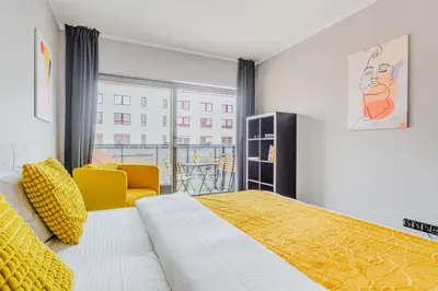 a kitchen with a wooden table and white cabinets at Spacious apartments near Karlín Square in Prague